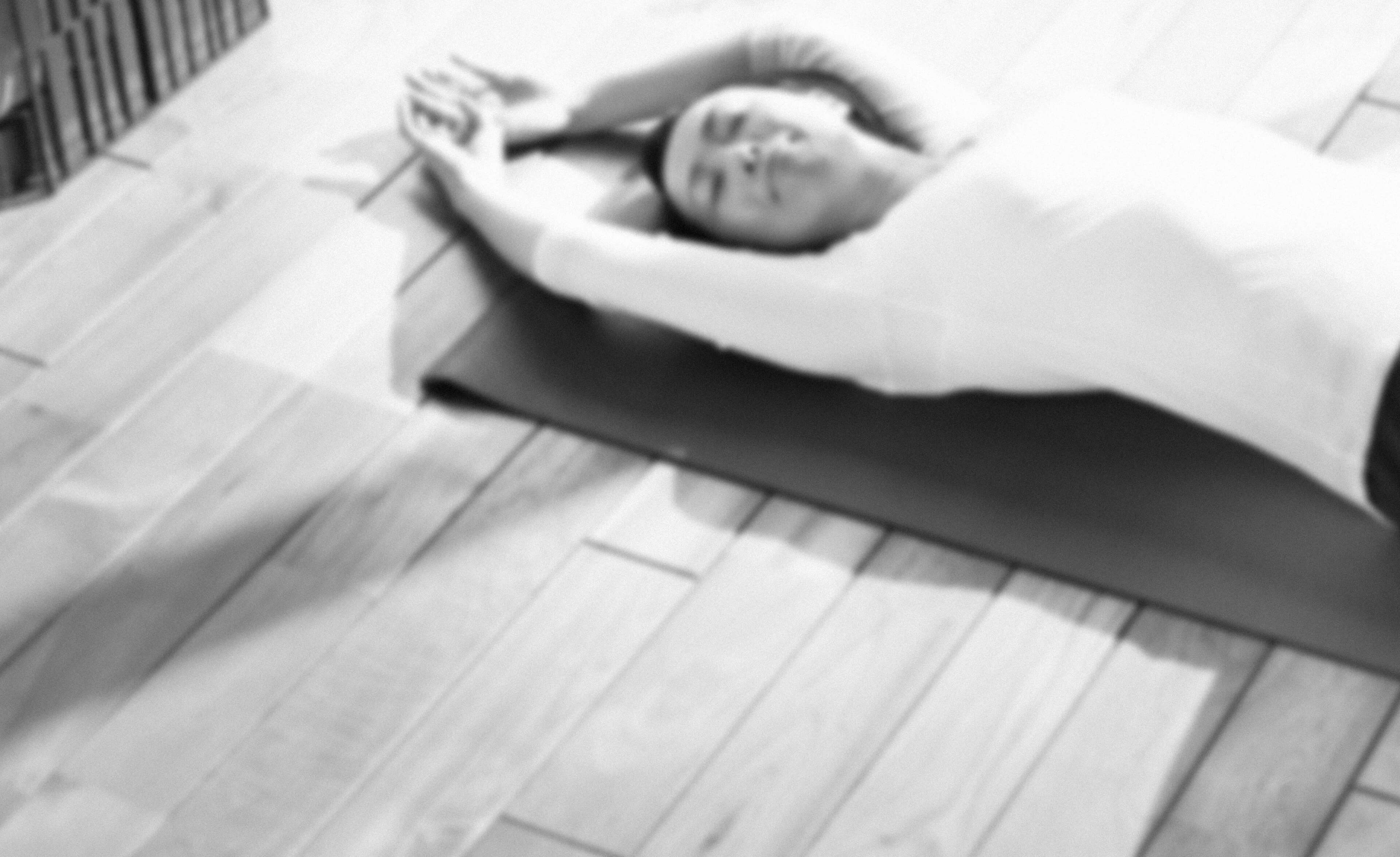 女性が木の床でくつろぐ様子の背景画像
